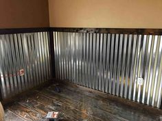 the inside of a room that is being remodeled with metal slats and wood flooring