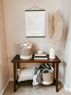 the neutral boho fall decor is displayed on a table with two baskets and a blanket