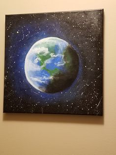 a painting of the earth is hanging on a wall