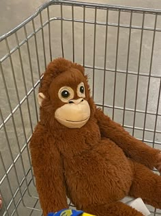 a stuffed monkey sitting in a shopping cart