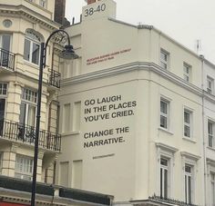 an advertisement on the side of a building in front of a street light and traffic lights