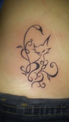 a cat tattoo on the back of a woman's lower back stomach, with swirls and leaves