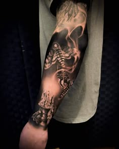 a man's arm with a skull and skulls tattoo on the forearm, in black and white