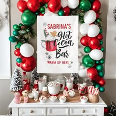 a christmas themed dessert bar with balloons and decorations on the wall, including candy canes, marshmallows, hot cocoa