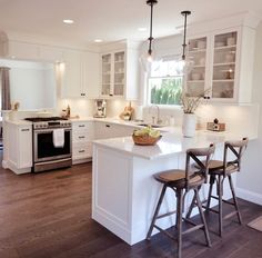 a kitchen with two stools and an island in front of the stove top oven