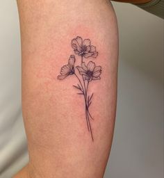 a small flower tattoo on the thigh