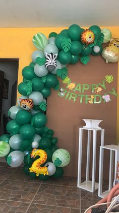 the balloon arch is decorated with jungle animals