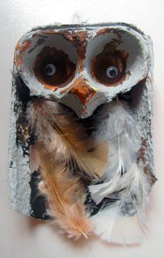 an owl made out of cement and feathers