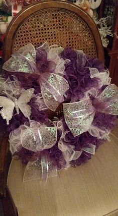 a purple wreath sitting on top of a wooden chair