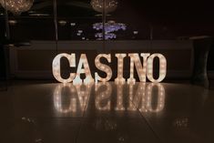 the word casino spelled with lights in front of a bar