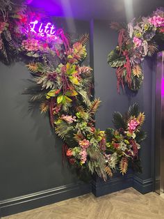 a purple and green wreath with the word lite on it in front of a blue wall