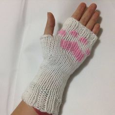 a hand that is wearing a knitted glove with pink letters on the palm and fingers