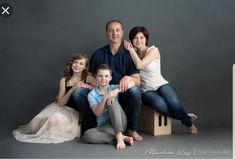 a family posing for a photo in front of a gray background