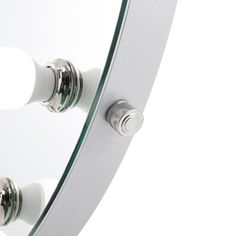 a round mirror with two knobs on the front and one in the back, is shown