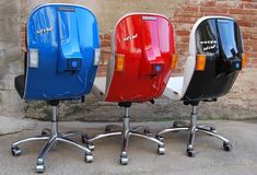 three different colored scooters sitting next to each other on top of metal wheels