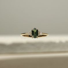 a close up of a ring with a green stone