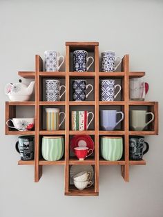 a wooden shelf filled with cups and saucers