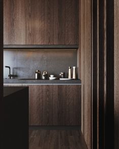 a kitchen with wooden cabinets and black counter tops, along with a sink in the center