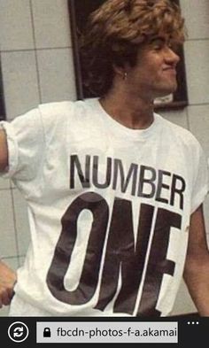 a young man holding a tennis racquet in his right hand and wearing a number one t - shirt