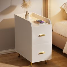 a white bedside table with two drawers and a phone on the top shelf next to it