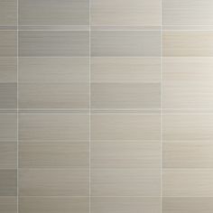 a tile wall that looks like it is made out of white and grey tiles,