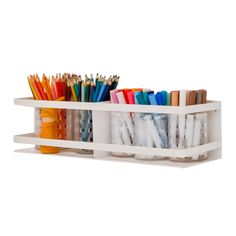 a white shelf filled with lots of pencils and markers