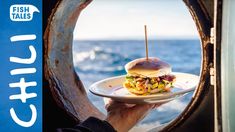 a person holding a plate with a sandwich on it in front of an open window