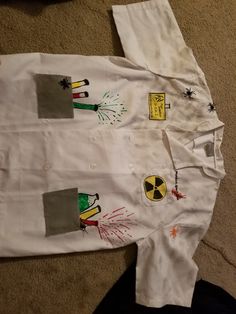 a white shirt with pictures on it laying on the floor