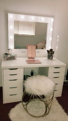 a white vanity with lights and a stool