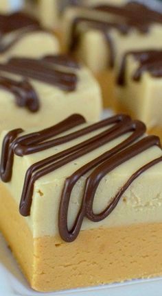 several pieces of cake on a plate with chocolate drizzled on top and white frosting