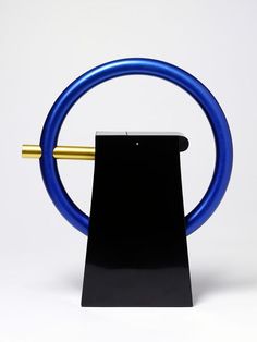 a black and blue object with a gold handle on it's end, in front of a white background