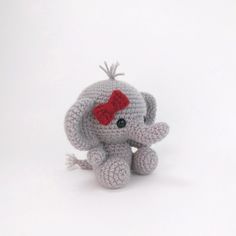 an elephant with a red bow on its head sitting in front of a white background