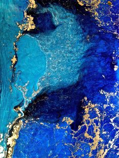 an abstract painting with blue and gold paint on the bottom, it looks like something from outer space