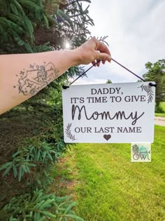 a hand holding a sign that says daddy it's time to give mommy our last name