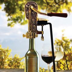 a wine bottle and glass sitting on top of a table next to a corkscrew