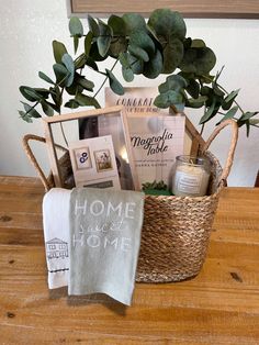 a basket filled with books and other items sitting on top of a wooden table next to a potted plant