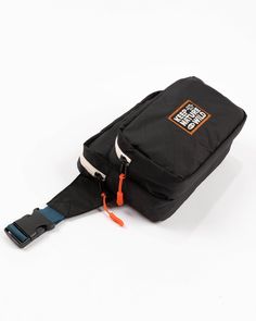 a small black bag with an orange handle on it's side and the strap down