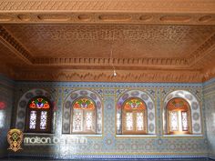 an ornately decorated room with stained glass windows and decorative tile work on the walls