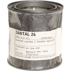 a candle that is inside of a metal can with labels on it and the words santal 26 written in white