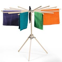 three towels are hanging on a clothesline with two wooden poles and one is colored