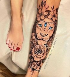 a woman's foot with a lion and roses tattoo on the side of her leg