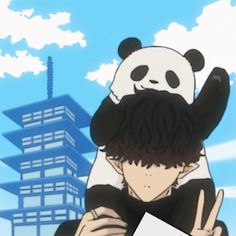 a panda bear sitting on top of a man's shoulders in front of a tall building