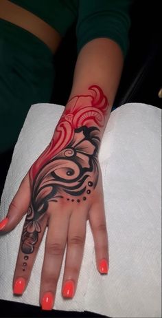 a woman's hand with red and black designs on it