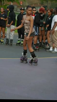 a young woman riding a skateboard down a street next to people on rollerblades