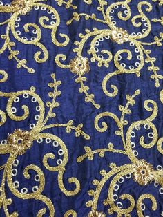 gold and blue fabric with intricate designs on it