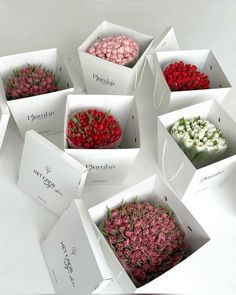 six open boxes with flowers in them sitting on a table