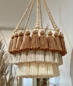 a chandelier hanging from the ceiling with tassels and beads on it