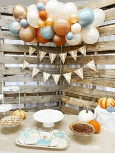 a table topped with lots of desserts and balloons