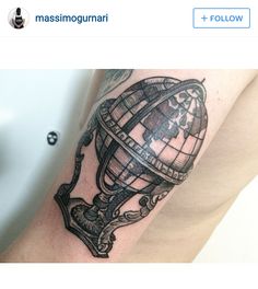 a man's arm with a globe tattoo on it