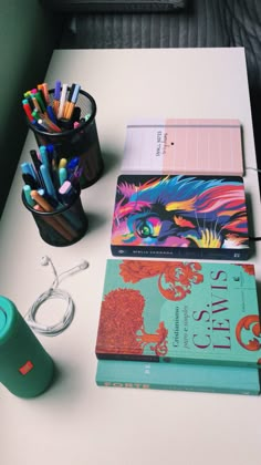 the desk is cluttered with books and pencils